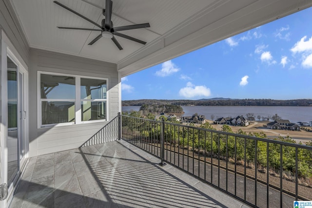 balcony with a water view and a ceiling fan