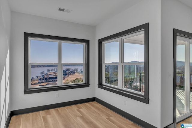 empty room with baseboards, visible vents, and light wood-style floors