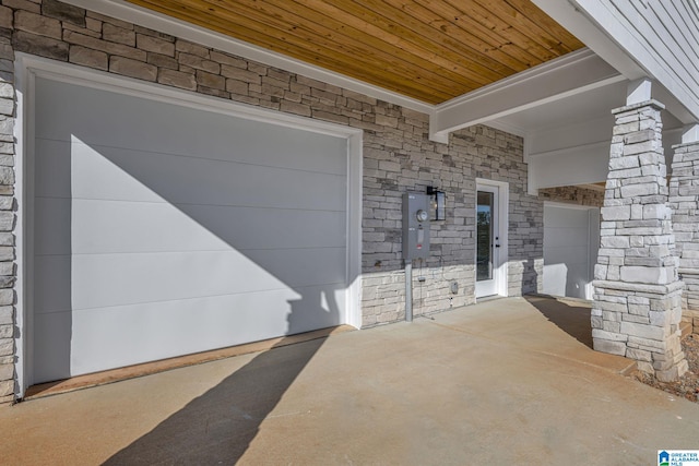 property entrance with a garage and stone siding