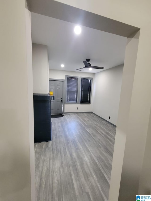 unfurnished living room featuring hardwood / wood-style flooring and ceiling fan