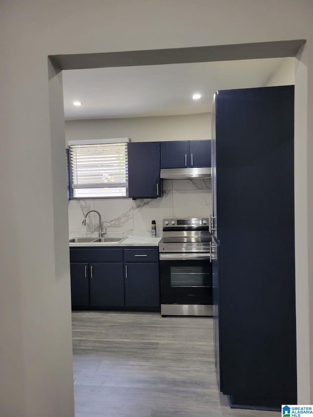 kitchen featuring sink, black refrigerator, stainless steel electric stove, and light hardwood / wood-style floors