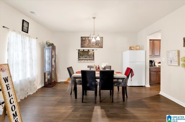 dining area featuring dark wood-type flooring and a notable chandelier