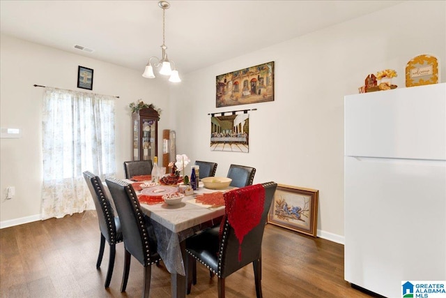 dining room featuring dark wood-type flooring and a notable chandelier