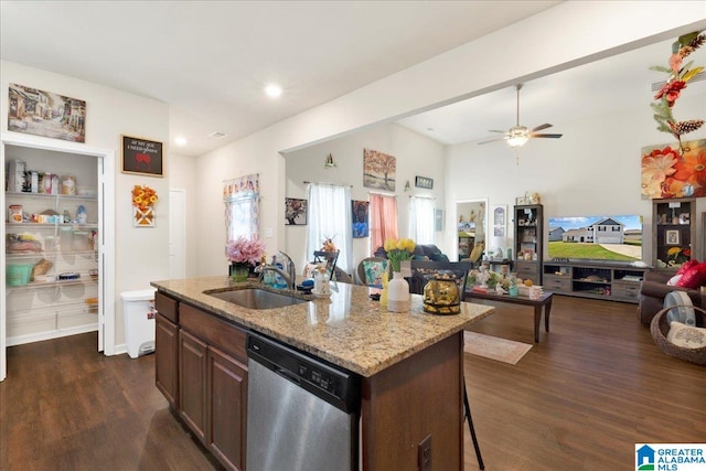 kitchen featuring sink, stainless steel dishwasher, dark hardwood / wood-style floors, a breakfast bar, and a center island with sink