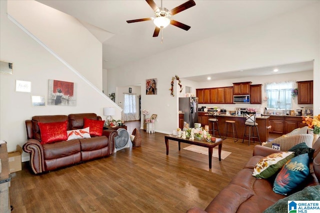 living room featuring dark hardwood / wood-style floors, high vaulted ceiling, and ceiling fan