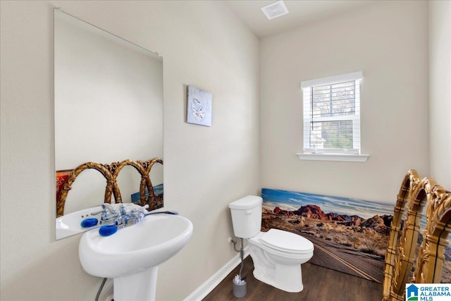 bathroom with wood-type flooring, toilet, and sink