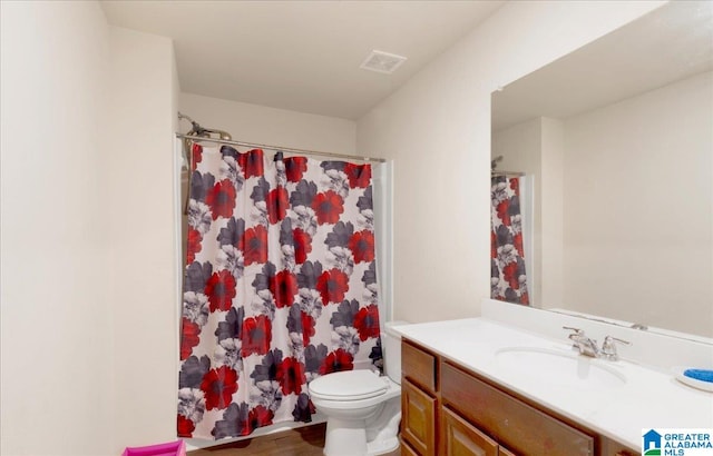 bathroom with hardwood / wood-style floors, vanity, toilet, and walk in shower