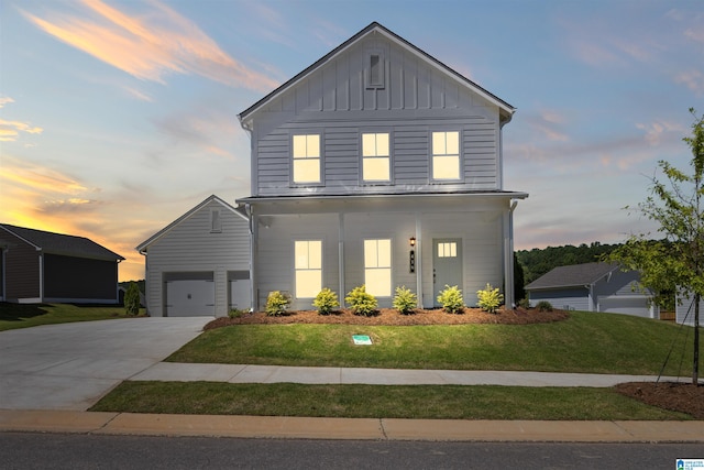 view of front of home with covered porch, a lawn, and a garage