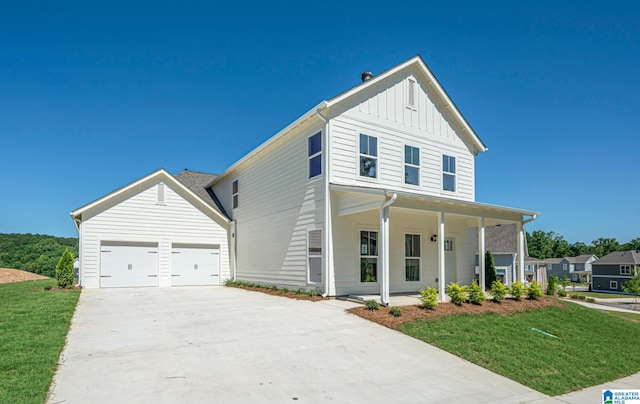 view of front facade with a porch, a front yard, and a garage