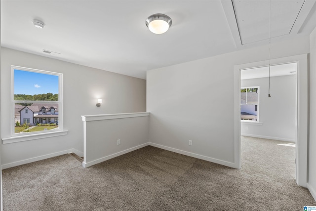 unfurnished room featuring carpet and plenty of natural light