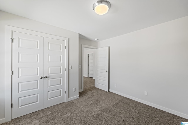 unfurnished bedroom with a closet and dark carpet