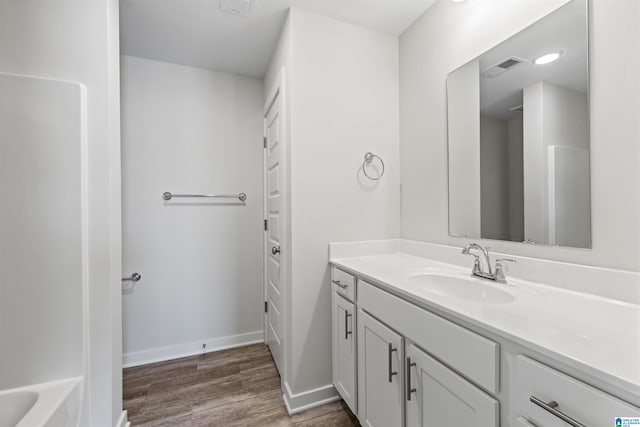 bathroom with a tub and vanity