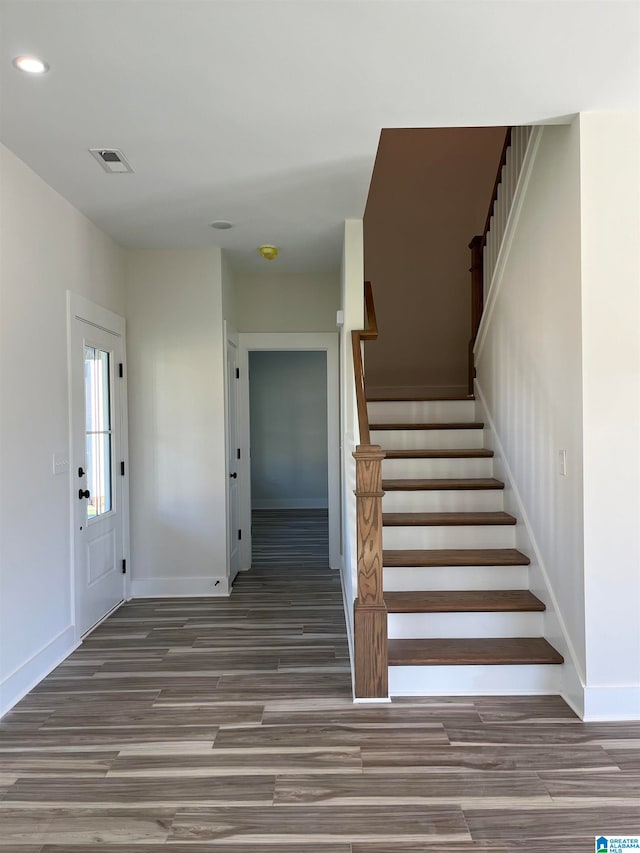 stairs featuring hardwood / wood-style floors