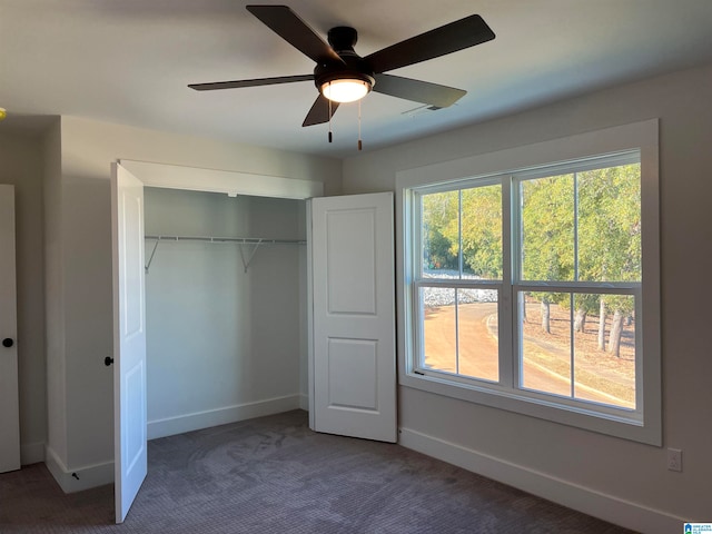 unfurnished bedroom with dark carpet, multiple windows, a closet, and ceiling fan