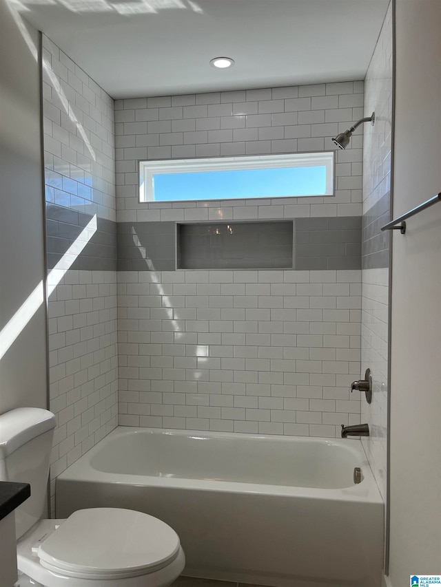 bathroom with tiled shower / bath and toilet