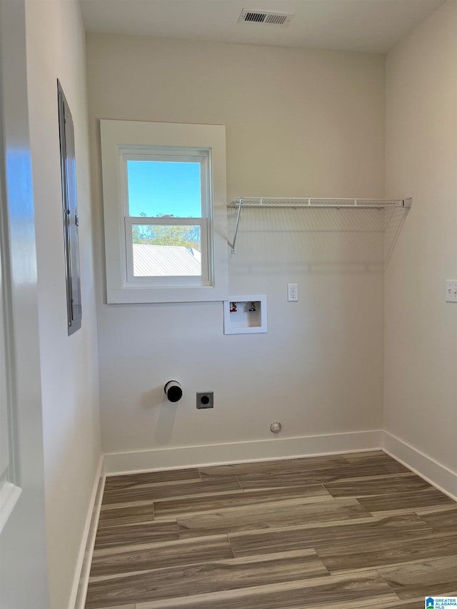 clothes washing area with hookup for an electric dryer, hookup for a washing machine, gas dryer hookup, and dark hardwood / wood-style flooring