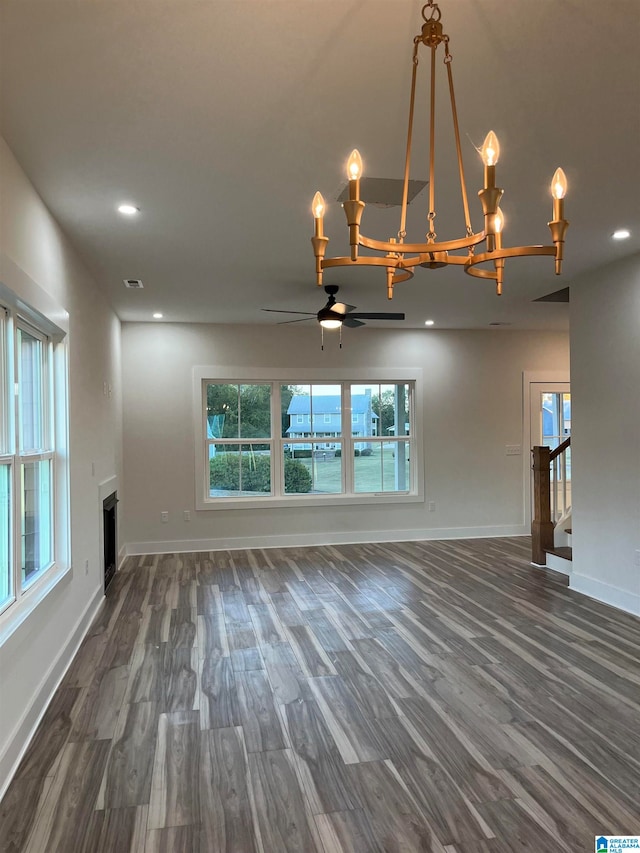 unfurnished living room featuring dark hardwood / wood-style floors and ceiling fan with notable chandelier