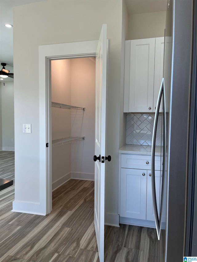 interior space featuring hardwood / wood-style floors, backsplash, and ceiling fan