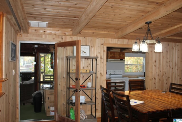 dining room featuring beam ceiling, wood walls, an inviting chandelier, and wood ceiling