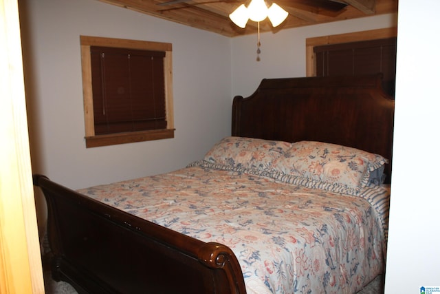 bedroom featuring beamed ceiling, wooden ceiling, and ceiling fan