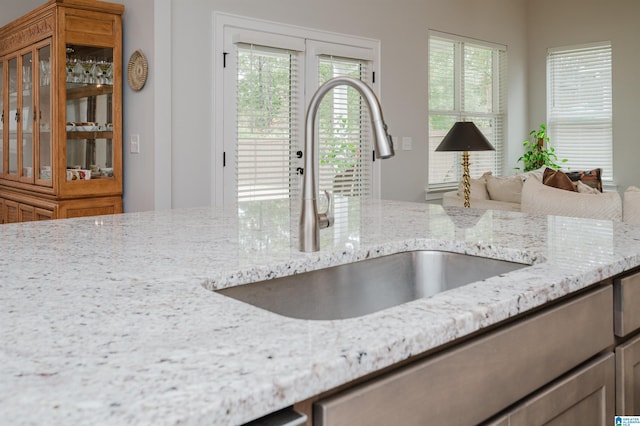 kitchen with light stone counters and sink