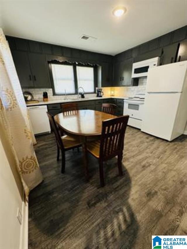 kitchen featuring sink, decorative backsplash, hardwood / wood-style flooring, and white appliances