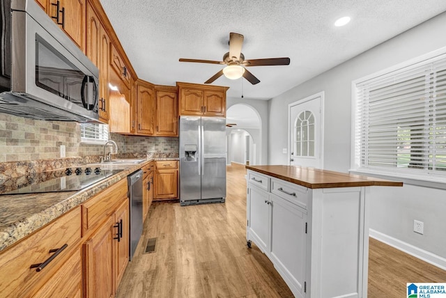 kitchen featuring stainless steel appliances, sink, white cabinets, and light wood-type flooring