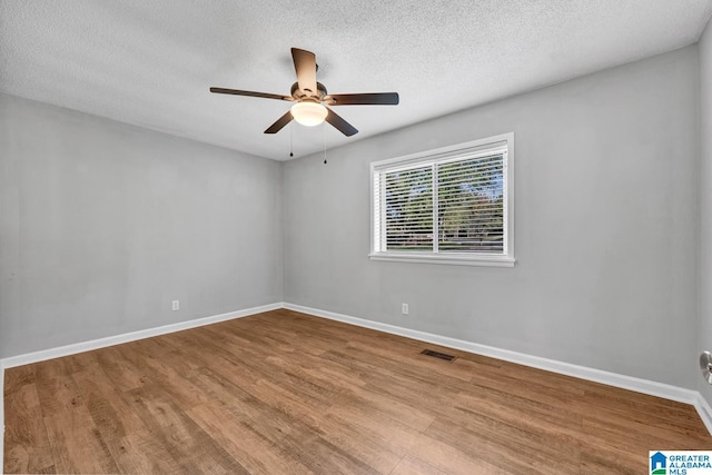 spare room featuring ceiling fan, a textured ceiling, and light wood-type flooring