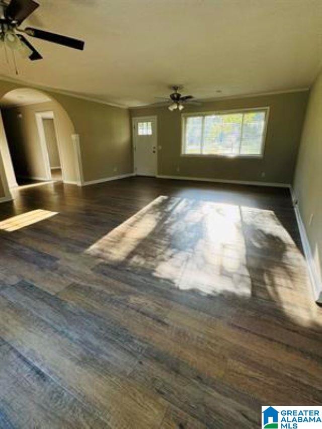 interior space with dark wood-type flooring, ceiling fan, and a wealth of natural light