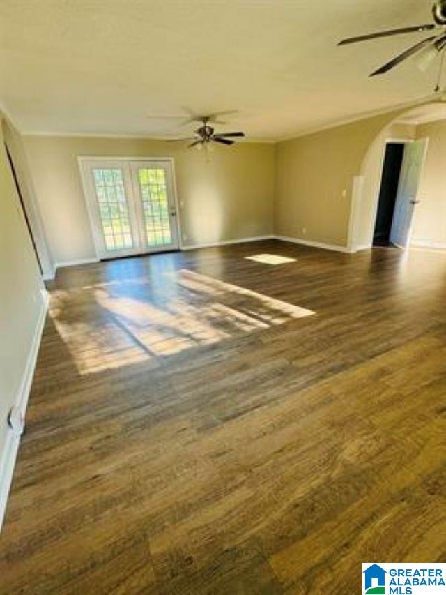 unfurnished living room with dark wood-type flooring and ceiling fan