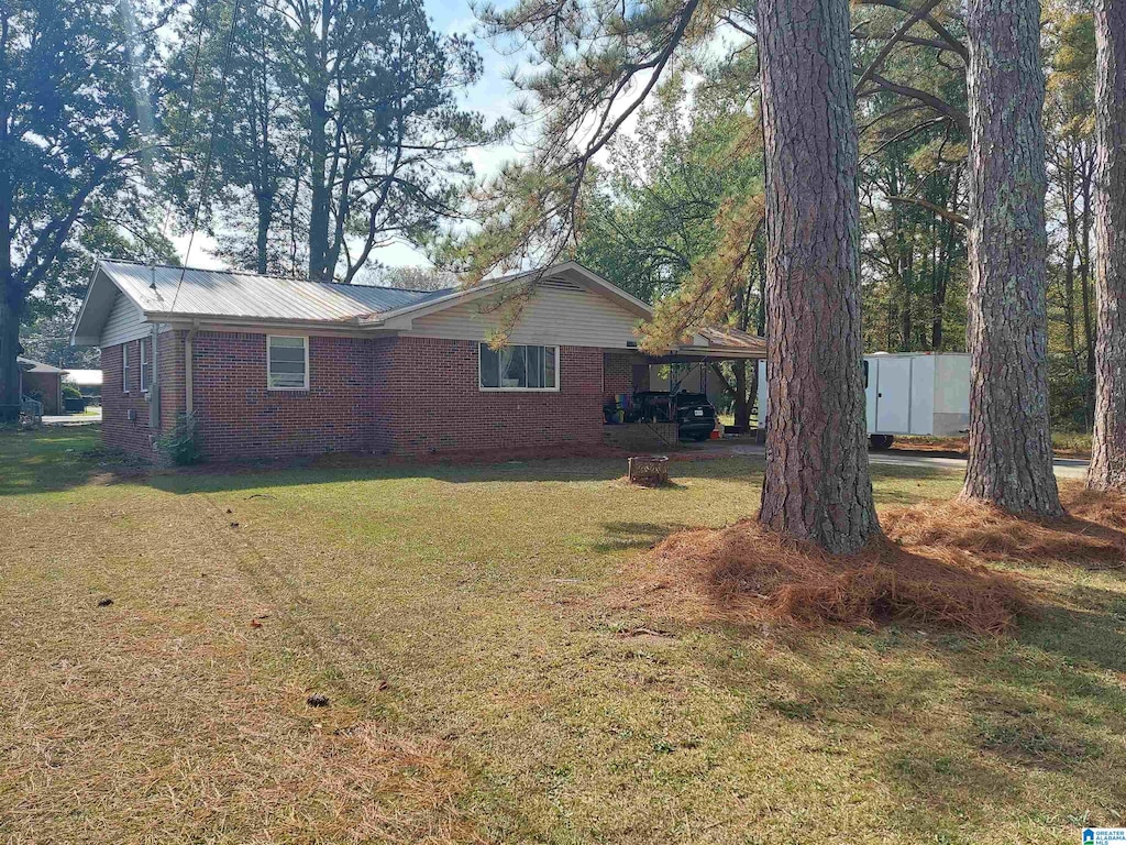 view of side of home with a lawn and a carport