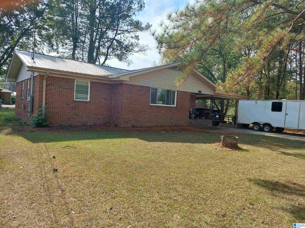 rear view of property featuring a yard and a carport