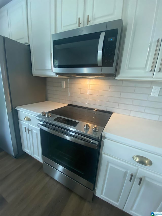 kitchen with backsplash, dark wood-type flooring, appliances with stainless steel finishes, and white cabinets