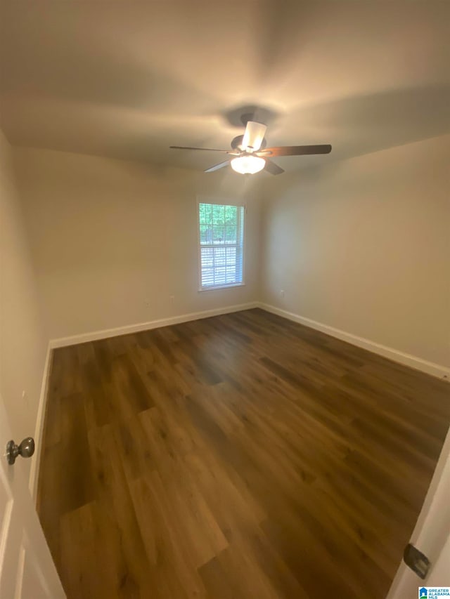 spare room with dark hardwood / wood-style floors and ceiling fan