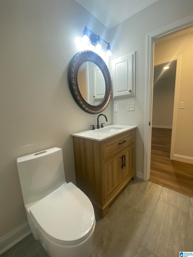 bathroom featuring vanity, hardwood / wood-style flooring, and toilet