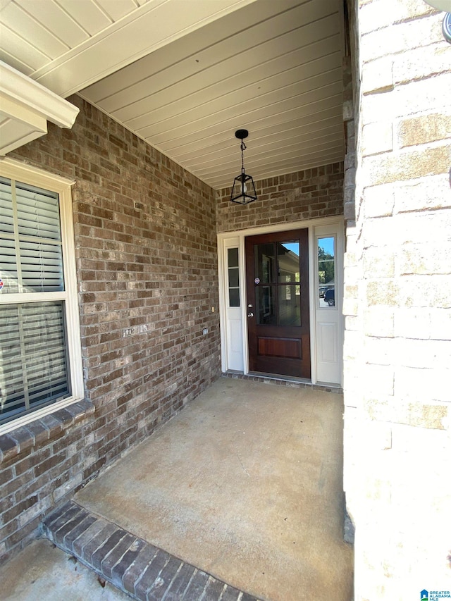 view of exterior entry with a patio area