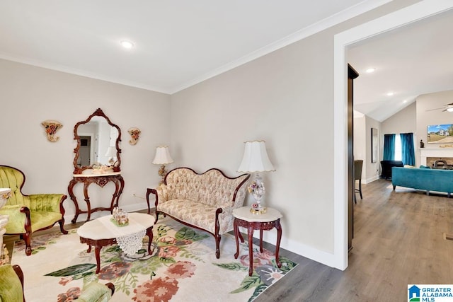 sitting room with crown molding, hardwood / wood-style flooring, lofted ceiling, and ceiling fan