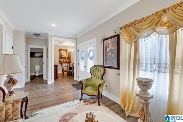 sitting room with hardwood / wood-style flooring, ornamental molding, and plenty of natural light