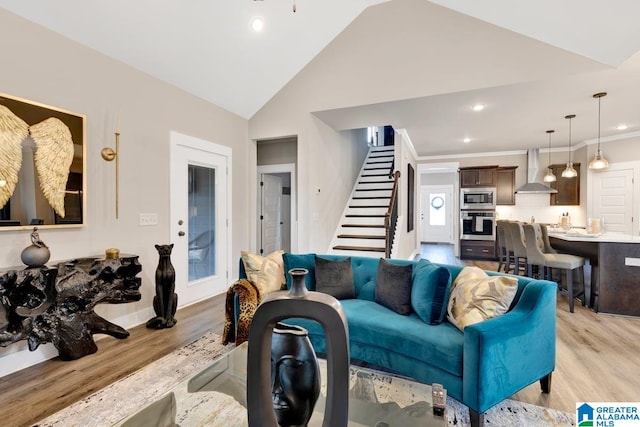 living room with ornamental molding, high vaulted ceiling, and light hardwood / wood-style floors