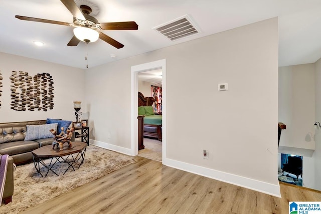 living room with light hardwood / wood-style floors and ceiling fan