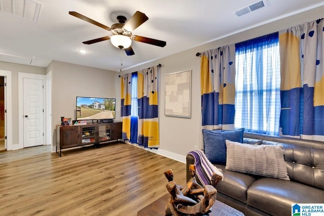 living room with a wealth of natural light, hardwood / wood-style flooring, and ceiling fan