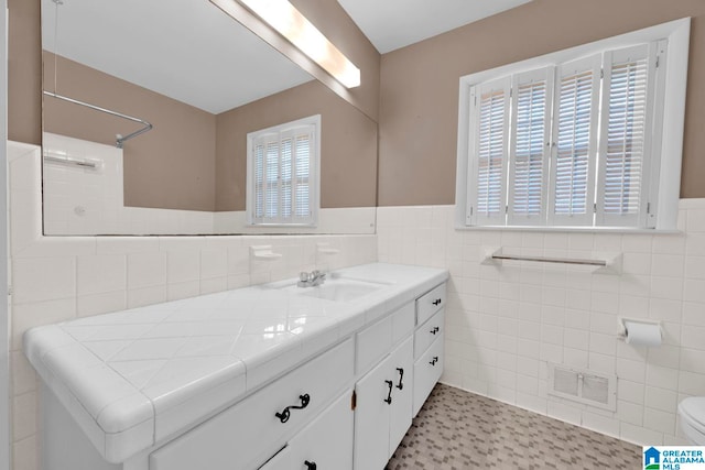 bathroom featuring tile walls, a wealth of natural light, vanity, and toilet