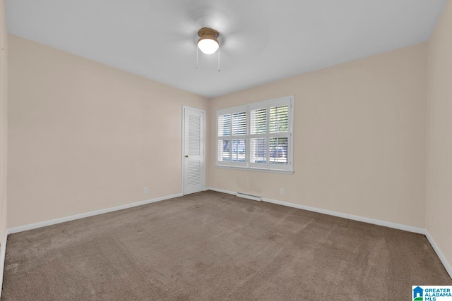 carpeted spare room with baseboard heating