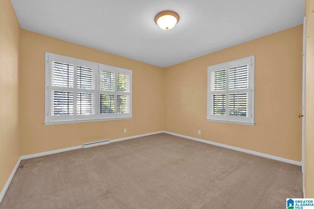 carpeted spare room with a baseboard radiator