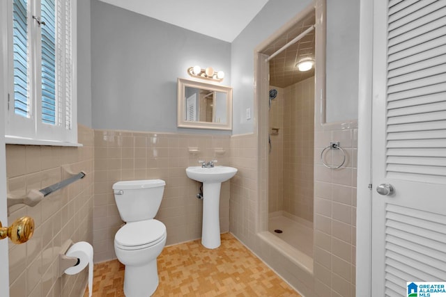 bathroom featuring toilet, tile walls, and tiled shower