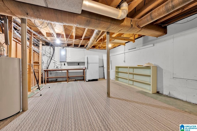 basement featuring water heater, electric panel, and white refrigerator