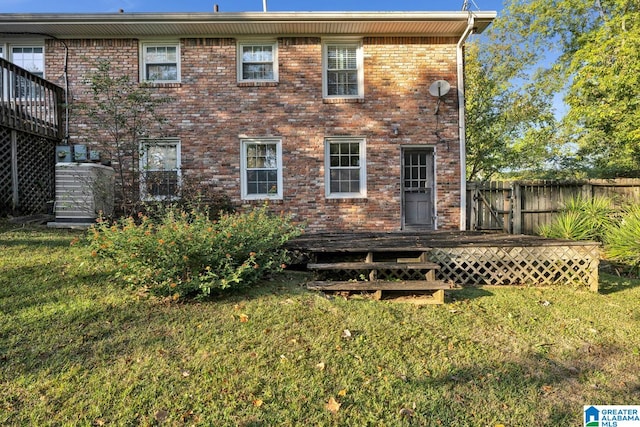 back of property featuring a deck and a yard