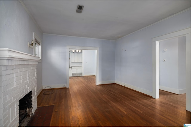 unfurnished living room with ornamental molding, a brick fireplace, and dark hardwood / wood-style flooring