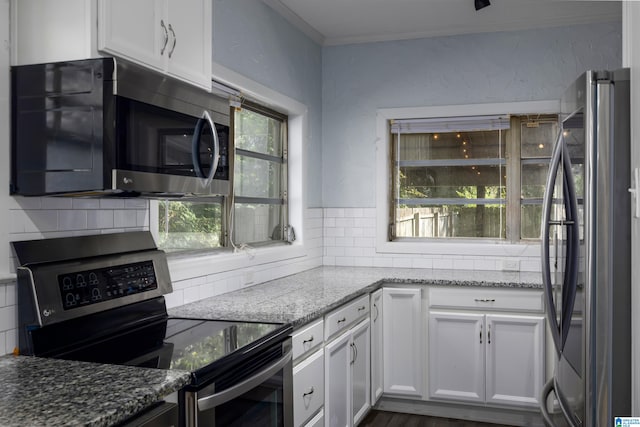 kitchen with plenty of natural light, white cabinetry, light stone counters, and stainless steel appliances