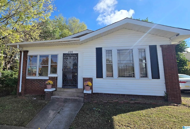 bungalow-style house with brick siding